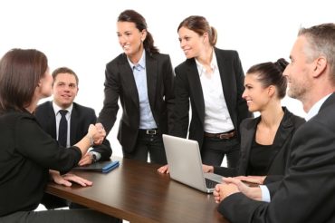Happy business people shaking hands perfect for follow-up NPS